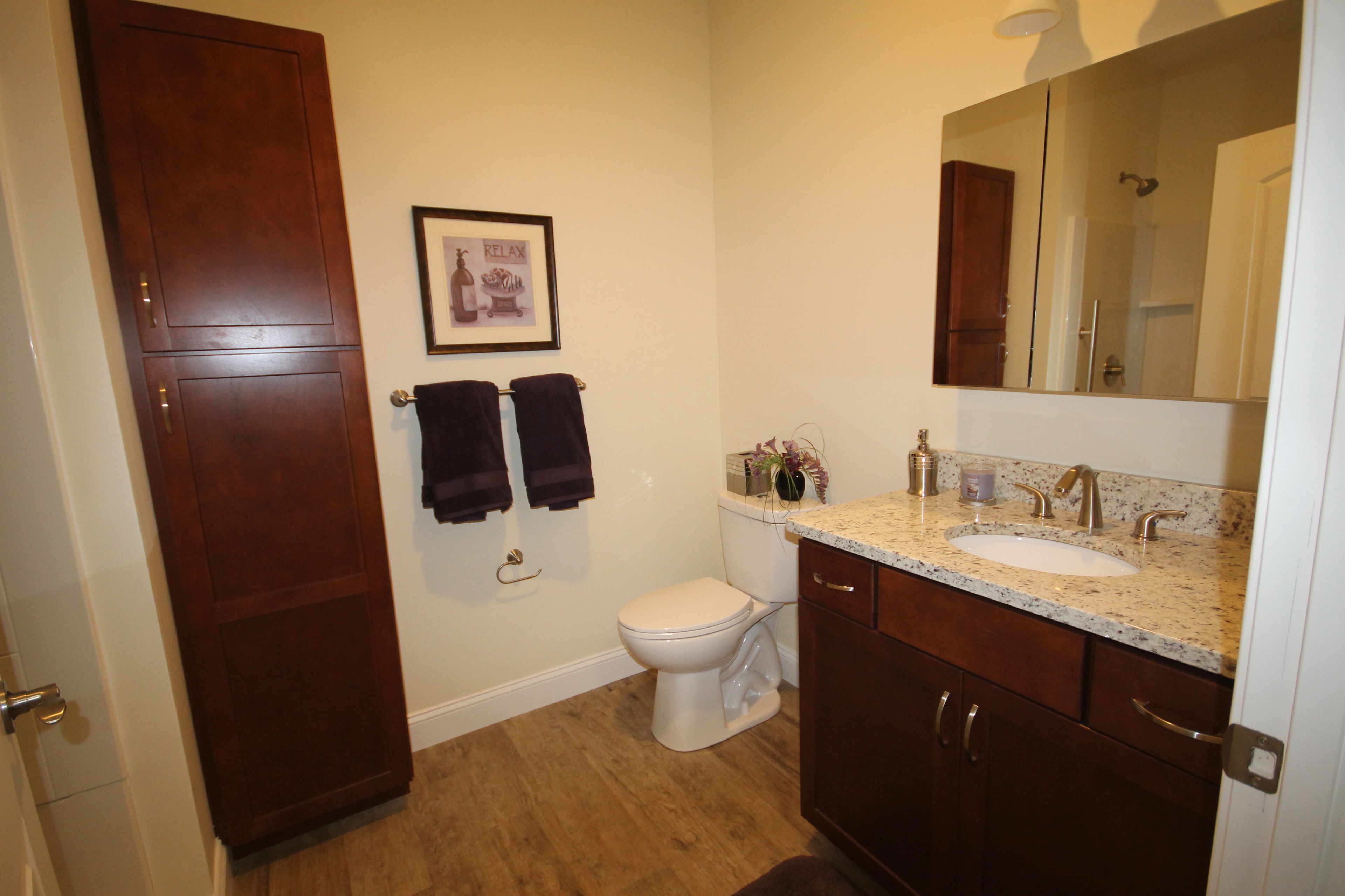 Bathroom with granite vanity and dark cabinetry
